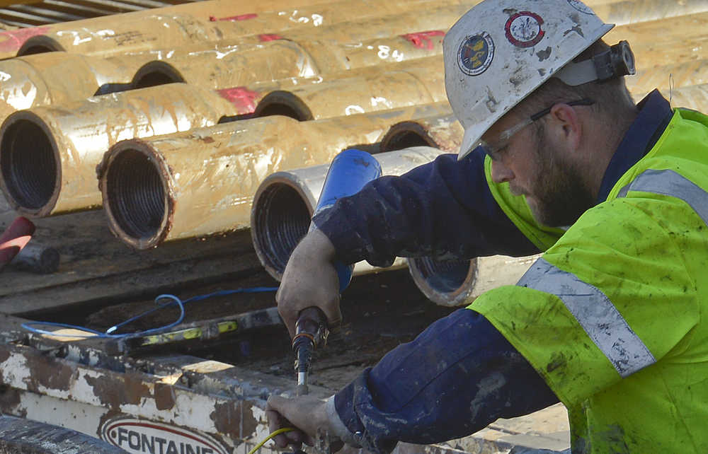 Photo by Rashah McChesney/Peninsula Clarion  An employee of the Arizona-based Southeast Directional Drilling runs a directional drill rig as it progresses toward the Kenai River along Bridge Access Road on Tuesday March 25, 2015 in Kenai, Alaska. The hole will eventually contain a portion of a four-mile pipeline that will connect an Enstar Natural Gas Company transmission line to the Cook Inlet Natural Gas Storage Alaska facility nearby.