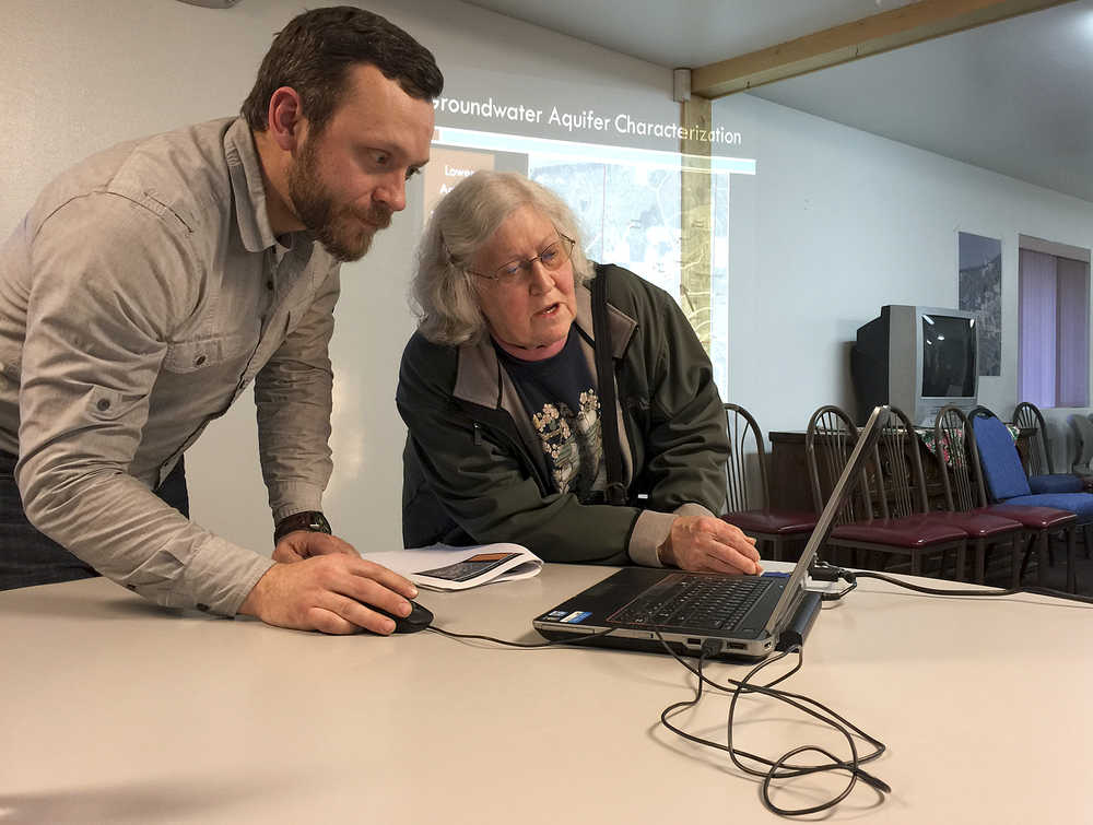 Photo by Rashah McChesney/Peninsula Clarion  DOWL HKM Environmental Specialist Paul Pribyl talks with a community member after presenting the results of a groundwater movement study on Monday March 23, 2015 in Nikiski, Alaska.