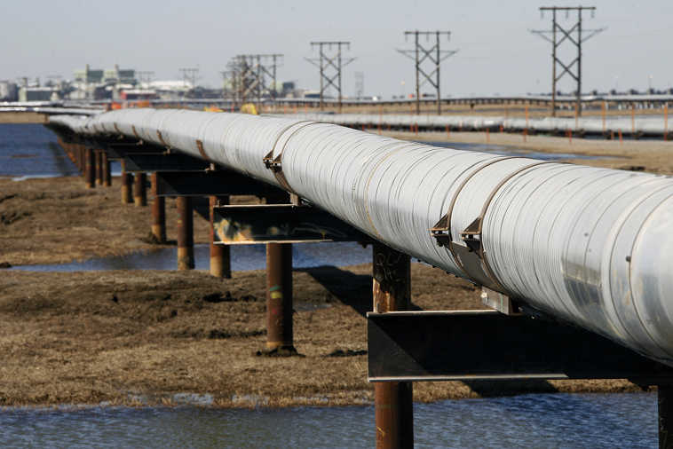 FILE - In this 2007 file photo, an oil transit pipeline runs across the tundra to flow station at the Prudhoe Bay oil field on Alaska's North Slope. The U.S. should immediately begin a push to exploit its enormous trove of oil in the Arctic waters off of Alaska, or risk a renewed reliance on imported oil in the future, an Energy Department advisory council says in a study to be released Friday, March 27, 2015. (AP Photo/Al Grillo, File)