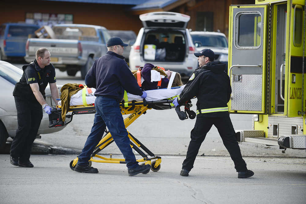 Photo by Rashah McChesney/Peninsula Clarion  Nikiski Fire Department paramedics load an injured woman into an ambulance after a car accident on Willow Street in Kenai, Alaska. Kenai Police said her injuries were not life-threatening. The driver of the pickup truck that made a left hand turn in front of her vehicle was uninjured, police said.