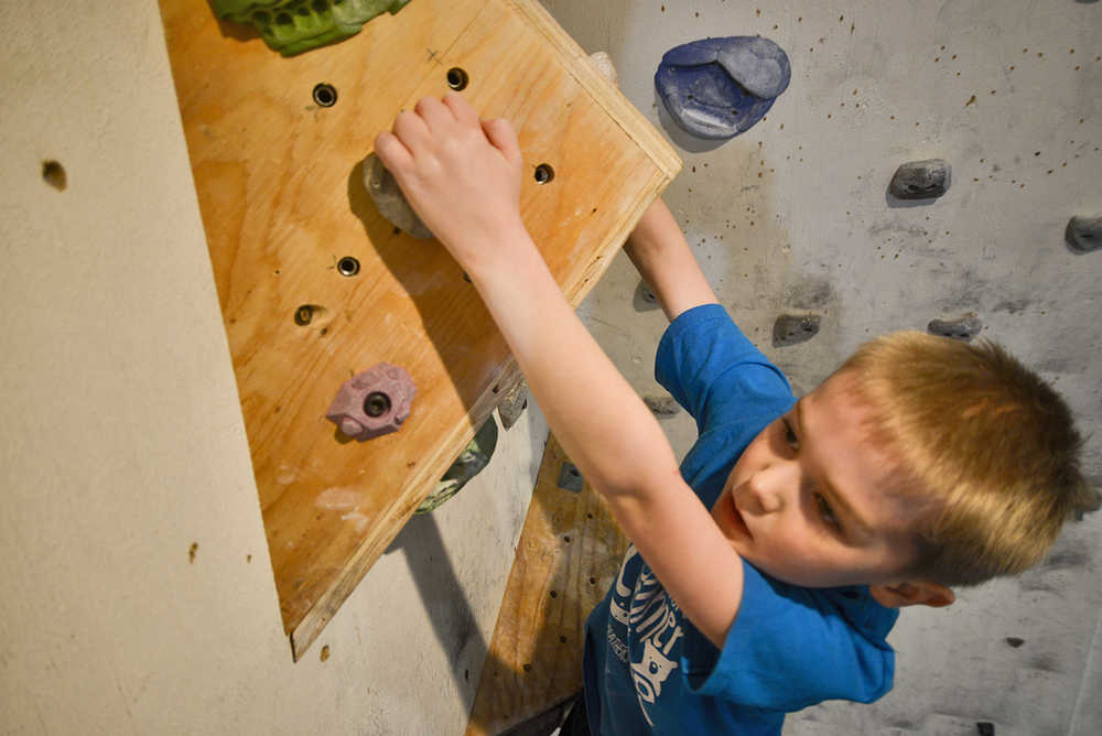 Photo by Rashah McChesney/Peninsula Clarion Brody Ireland, 9, looks for a handhold at the Redoubt Rock Climbing in Nic and Natalie Larson's home on Wednesday April 1, 2015 in Soldotna, Alaska. The Larsons offer climbing lessons and open gym periods in their Soldotna home.