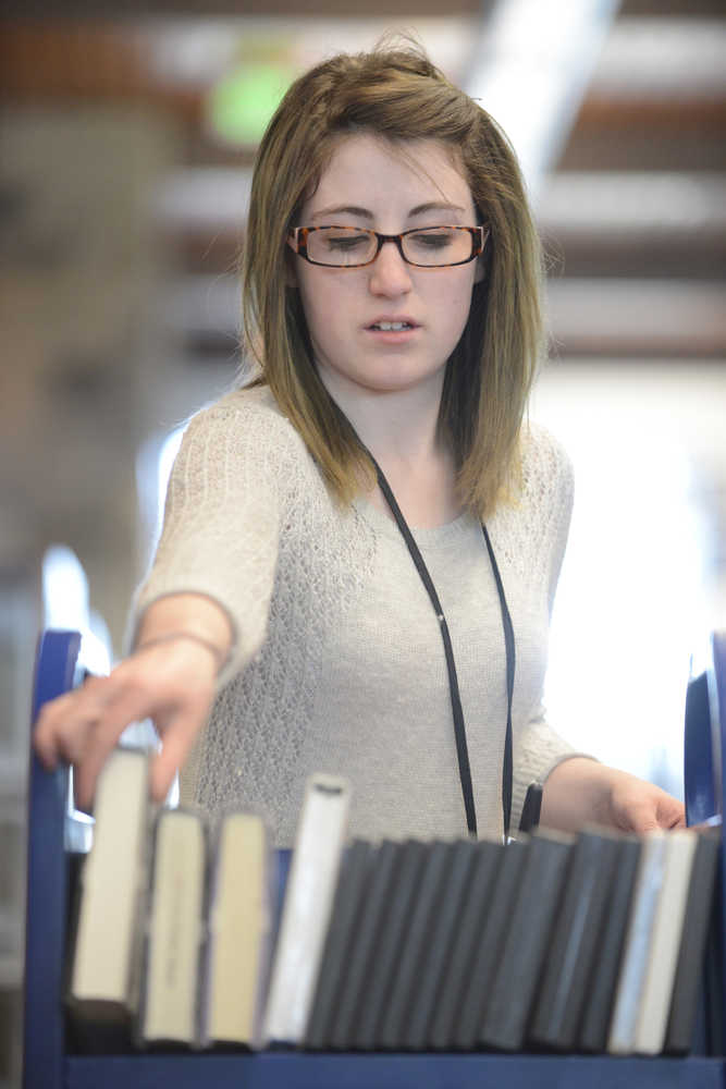 Photo by Kelly Sullivan/ Peninsula Clarion Heather Schaefer puts books away at the Joyce K. Carver Soldotna Public Library Monday, April 13, 2015, in Soldotna, Alaska. She said she noticed there were quite a few books in the book drop that afternoon, but was unsure if it had to do with the Food for Fines program, or that it hadn't been checked yet.