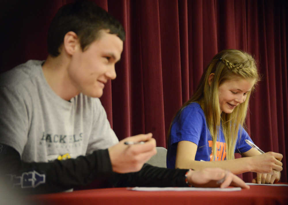 Photo by Kelly Sullivan/ Peninsula Clarion Kenai Central seniors Allie Ostrander and Jonah Theisen sign off on their college's of choice Wednesday, April 15, 2015, at Kenai Central High School in Kenai, Alaska.