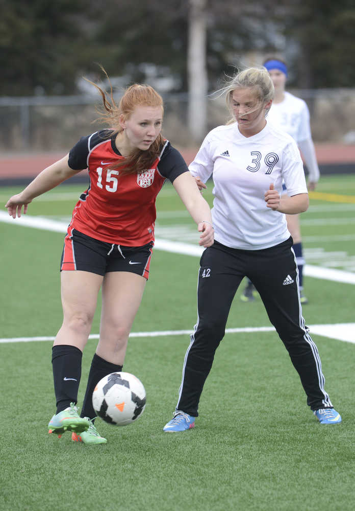 Photo by Kelly Sullivan/ Peninsula Clarion Kenai High School's Darby Milburn passes the ball off to a teammate before Soldotna High School's Bailey Rosen can intercept the pass Friday, April 17, 2015, at Kenai Central High School in Kenai, Alaska.