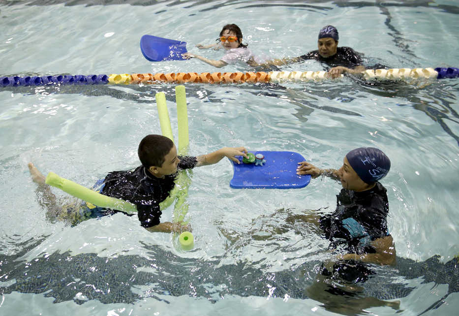 Young swimmers and their teachers swim in a pool during a swim lesson in the Bronx borough of New York, Wednesday, April 15, 2015. They are in swim swim swim I SAY, one of 65 programs around the country to receive grants from the nonprofit Autism Speaks to provide the personal attention and patience if often takes to help children on the autism spectrum learn to swim. Many are prone to wander and many are drawn to water.(AP Photo/Seth Wenig)