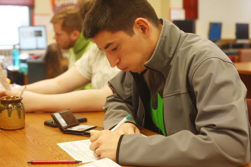 Photo by Kelly Sullivan/ Peninsula Clarion River City Academy Senior Logan Triggs takes a breath before filling out his voter registration form Tuesday, April 28, 2015, at River City Academy in Soldotna, Alaska.