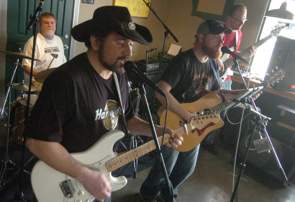 Ben Boettger/Peninsula Clarion Lee Gattenby (left) plays an electric guitar solo alongside vocalist and rhythm guitarist Eric Doucet during a show on Sunday, April 25 at Coffee Roasters in Kenai.