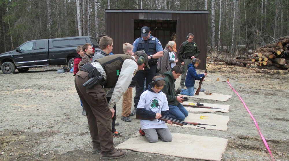 Officers Shay Hurd (Kenai National Wildlife Refuge), Daniel Carnow (NOAA), and Jacques Kosto (Alaska State Parks) help kids learn to shoot with air rifles. (Photo courtesy Kenai National Wildlife Refuge)