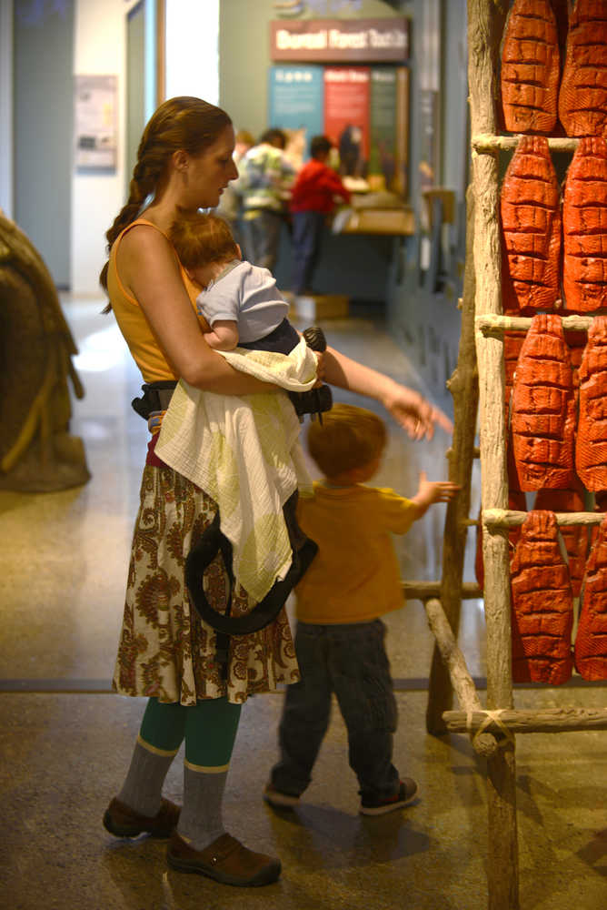 Ben Boettger/Peninsula Clarion Lacy Ledahl and her children Iver and Ottar examine a model salmon-drying rack at the new Kenai Wildlife Refuge visitor center on Friday, May 3. "It's beautiful. Much nicer than the one we had when I was a kid," Ledahl said of the new visitor center. "I told (Iver) he could push all the buttons--that's why we were here so long."