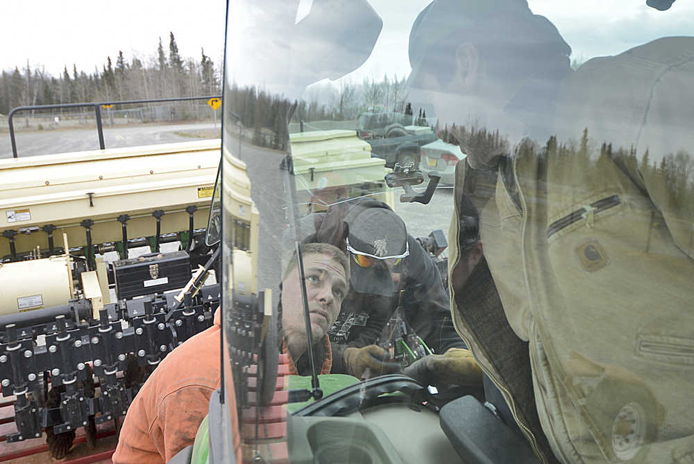 Photo by Rashah McChesney/Peninsula Clarion Larry Marsh pours seed into a no-till seed planter on Tuesday May 5, 2015 at the rodeo grounds in Soldotna, Alaska. The Kenai Soil and Water Conservation District requires that farmers train on certain pieces of its rental equipment before using them. It hosted a training meeting on the seed planter and participants helped to seed a field at the rodeo grounds.