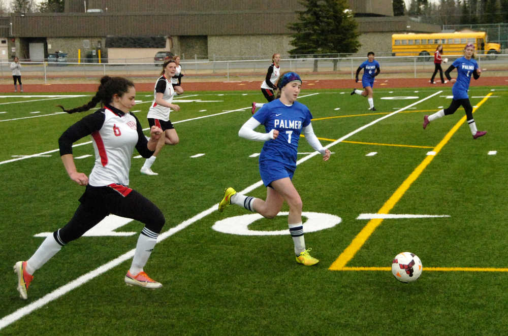 Ben Boettger/Peninsula Clarion Kenai Central High School Girl's Varsity soccer player Cassi Holmes and Palmer's Kiley Fish chase the ball at a match on Friday, May 8 at Kenai Central High School.