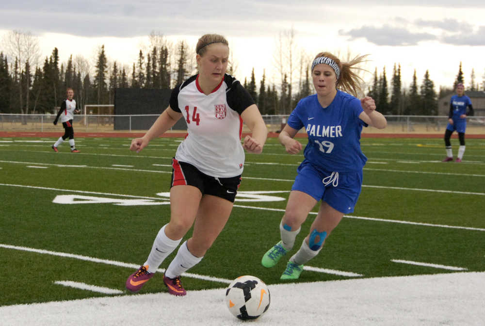 Ben Boettger/Peninsula Clarion Kenai Central High School Girl's Varsity soccer player Hannah Drury (left) fights for the ball with Palmer's Caile Dosser at match on Friday, May 8 at Kenai Central High School.