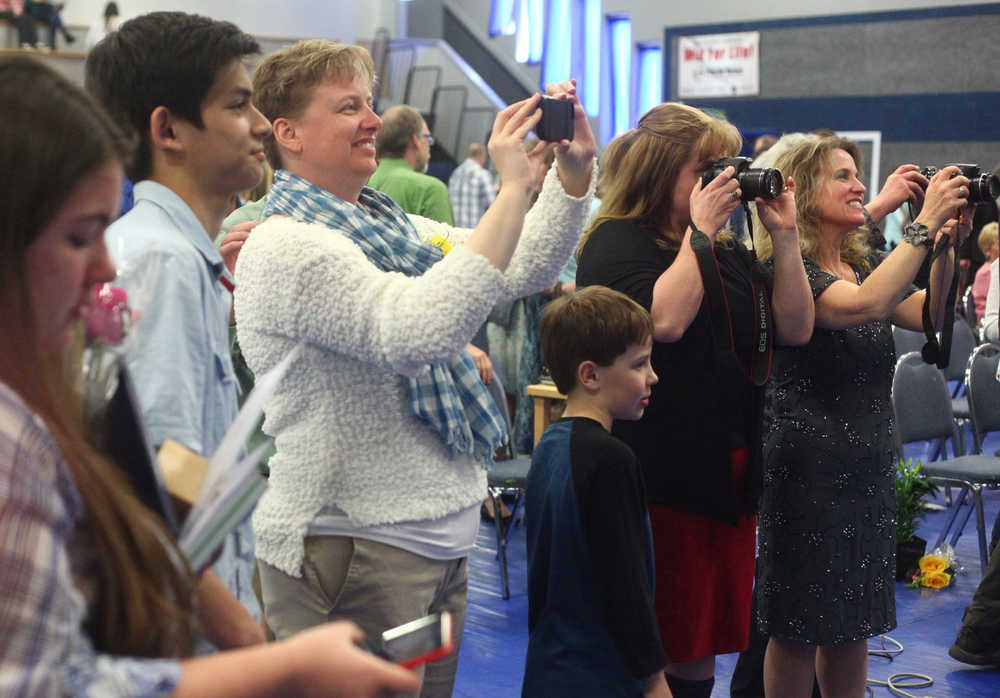 Photo by Kelly Sullivan/ Peninsula Clarion Family and friends of the 2015 Cook Inlet Academy class snap photographs of the six graduates Sunday, May 10, 2015, at Cook Inlet Academy in Soldotna, Alaska.
