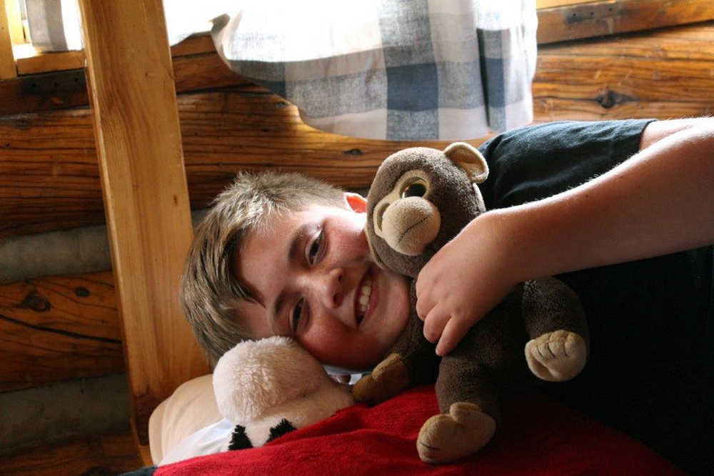 In this August 2013 photo provided by Sanborn Western Camps, a Junior camper holds his stuffed animal "friend" at camp in Florissant, Colo. Overcoming homesickness and spending time away from parents helps children gain self-assurance and independence, experts say.  (AP Photo/Sanborn Western Camps, Jeff Krueger)