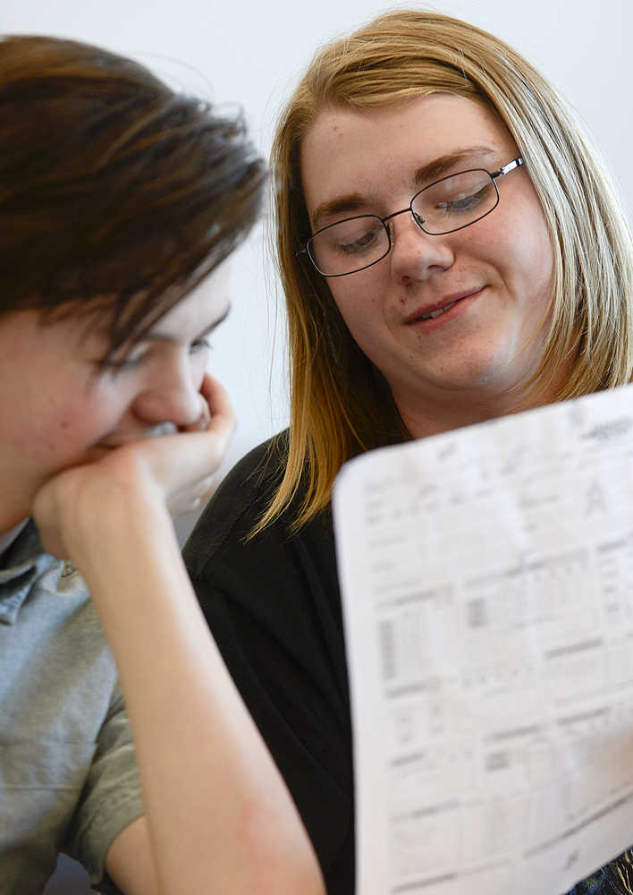 Photo by Rashah McChesney/Peninsula Clarion   (left) Morgan Stoddard laughs as Hans Hesse shows him a character sheet during their Dungeons & Dragons game on April 22, 2015 at the Soldotna Public Library. The group meets regularly at the library and will host a D&D marathon on Saturday for anyone in the community interested in playing the game.