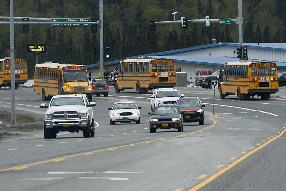 Photo by Rashah McChesney/Peninsula Clarion  Several busses head to Kenai Peninsula School District schools which were put in a modified lockdown mode Wednesday  May 13, 2015 when the district received a computerized threatening telphone call.
