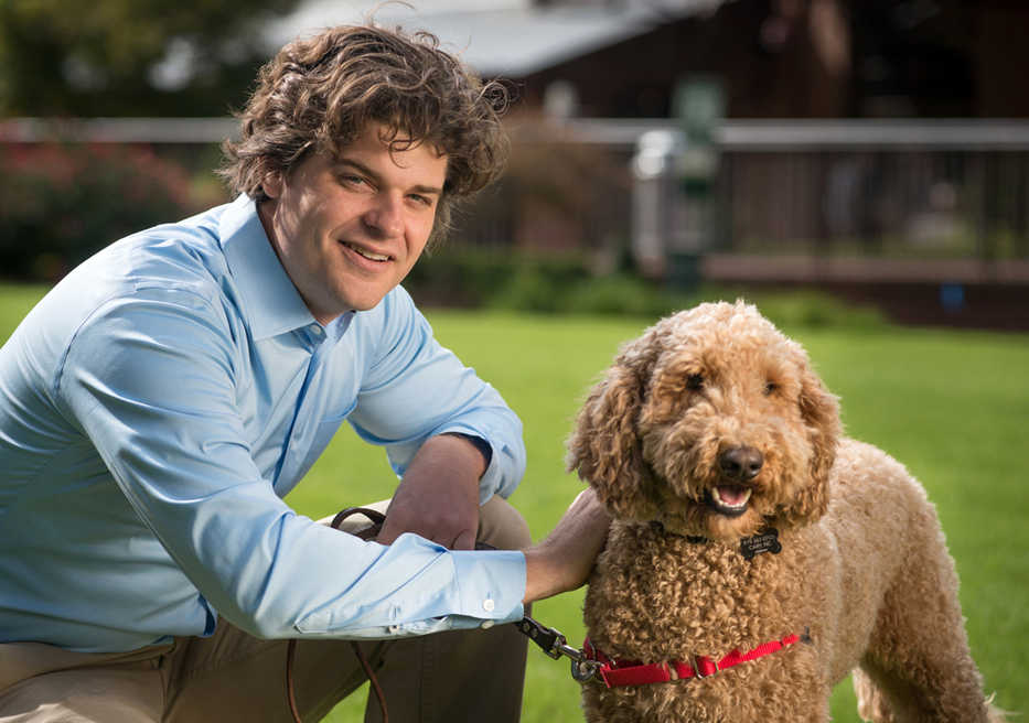 In this October 2012 photo provided by the National Geographic Channels, Dr. Brian Hare kneels with Finley the dog in Durham, N.C. On the weekend of May 15, 2015, Nat Geo Wild will air a three-part series called "Is Your Dog a Genius?" It will be part of the network's inaugural "BarkFest" weekend with one show after another dedicated to dogs. Hare, associate professor of evolutionary anthropology at Duke University and a member of the Center for Cognitive Neuroscience, part of the Duke Institute for Brain Sciences, will host the show.  (Christer Berg/Dognition via AP)