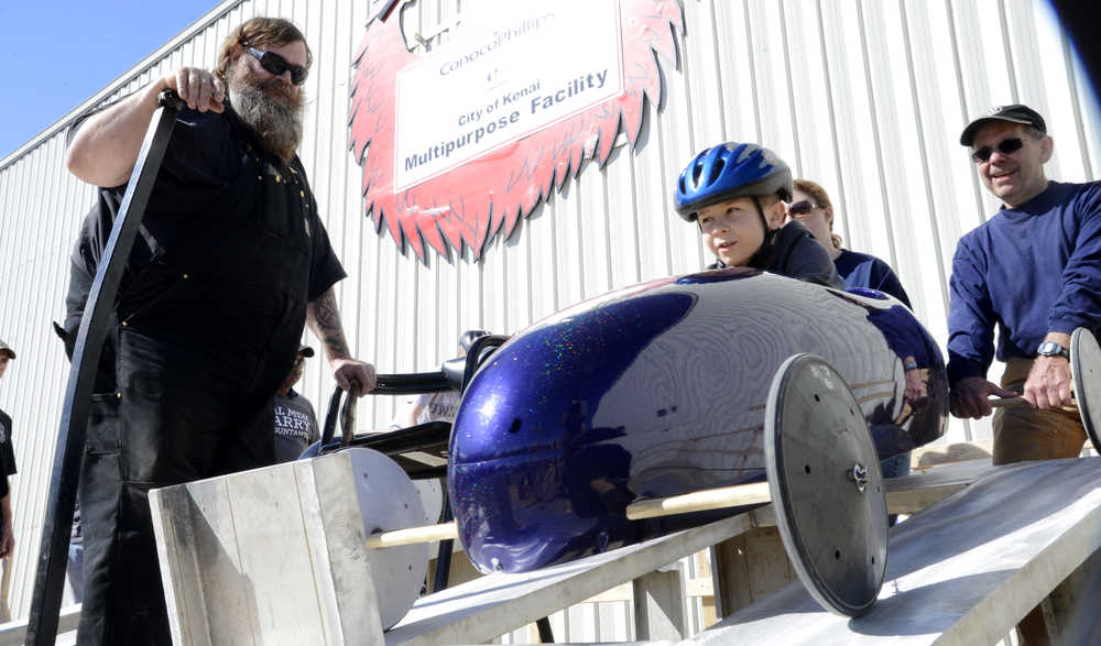Ben Boettger/Peninsula Clarion Organizer Scott Hamann (left) looks on while champion racer Wyatt Wasczak is placed on the starting ramp during the Kenai Rotary Soapbox Derby in the parking lot of Kenai's Challenger Learning Center.