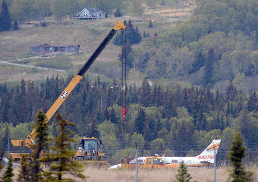 A crane moves into position to life up an Alaska Air Transit plane that landed with wheels up at the Homer Airport on Saturday afternoon.