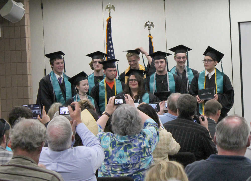 Photo by Will Morrow/Peninsula Clarion Members of the River City Academy Class of 2015 pose for photos after turning their tassels during a commencement ceremony Monday, May 18, 2015 at the Soldotna Regional Sports Complex.