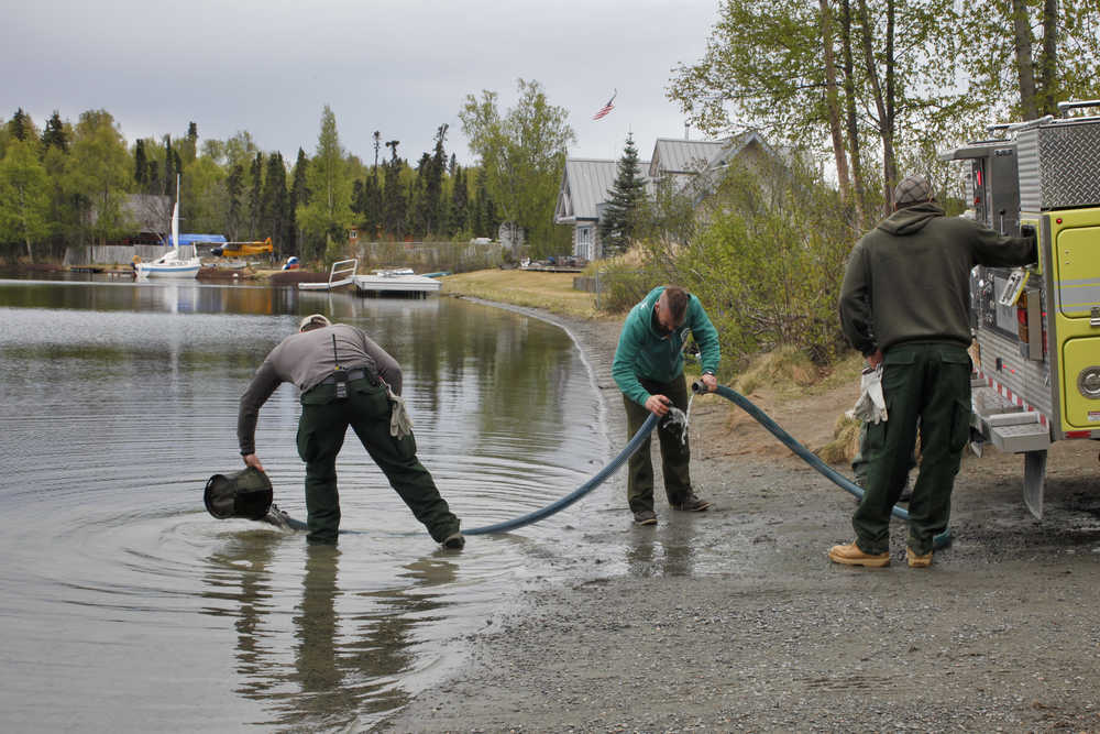Photo by Rashah McChesney/Peninsula Clarion  Firefighters from the Soldotna office of the Alaska Division of Forestry draw water out of Sport Lake during a brief training on Tuesday May 19, 2015 in Soldotna, Alaska. Firefighters said conditions are hot and dry enough to merit concern and an elevated level of fire danger on the Kenai Peninsula.