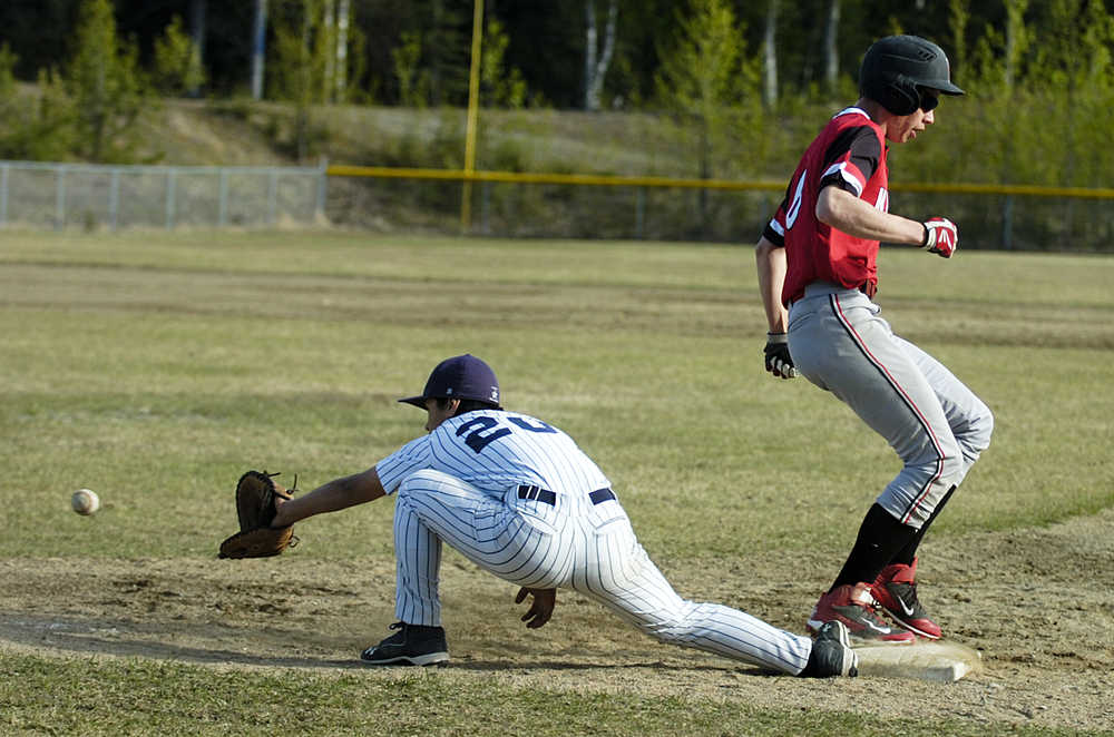 Photo by Rashah McChesney/Peninsula Clarion Soldotna Stars' Terrence Slats reaches for ball as Kenai Kardinals' Brandon Sorhus safely makes it to first base during their game on Friday May 22, 2015 in Soldotna, Alaska. Soldotna won the game 5-4.