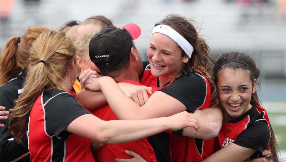 A group of Kenai Kardinals hug head coach Dan Verkuilen after the Kards beat Soldotna 3-2 in overtime of the Northern Lights Conference girls' title match May 23 at Palmer High School.