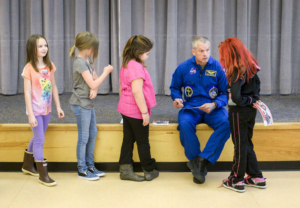 ADVANCE FOR SUNDAY, MAY 24 - In this photo taken May 6, 2015, Astronaut Steve Swanson signs autographs for a group of students at Fawn Mountain Elementary School in Ketchikan, Alaska.  Swanson visited the school as part of American300's tour of Alaska. American300 is an all-volunteer, nonprofit organization that brings interesting and relevant guests to U.S. service stations around the world. (Taylor Balkom/Ketchikan Daily News via the AP)