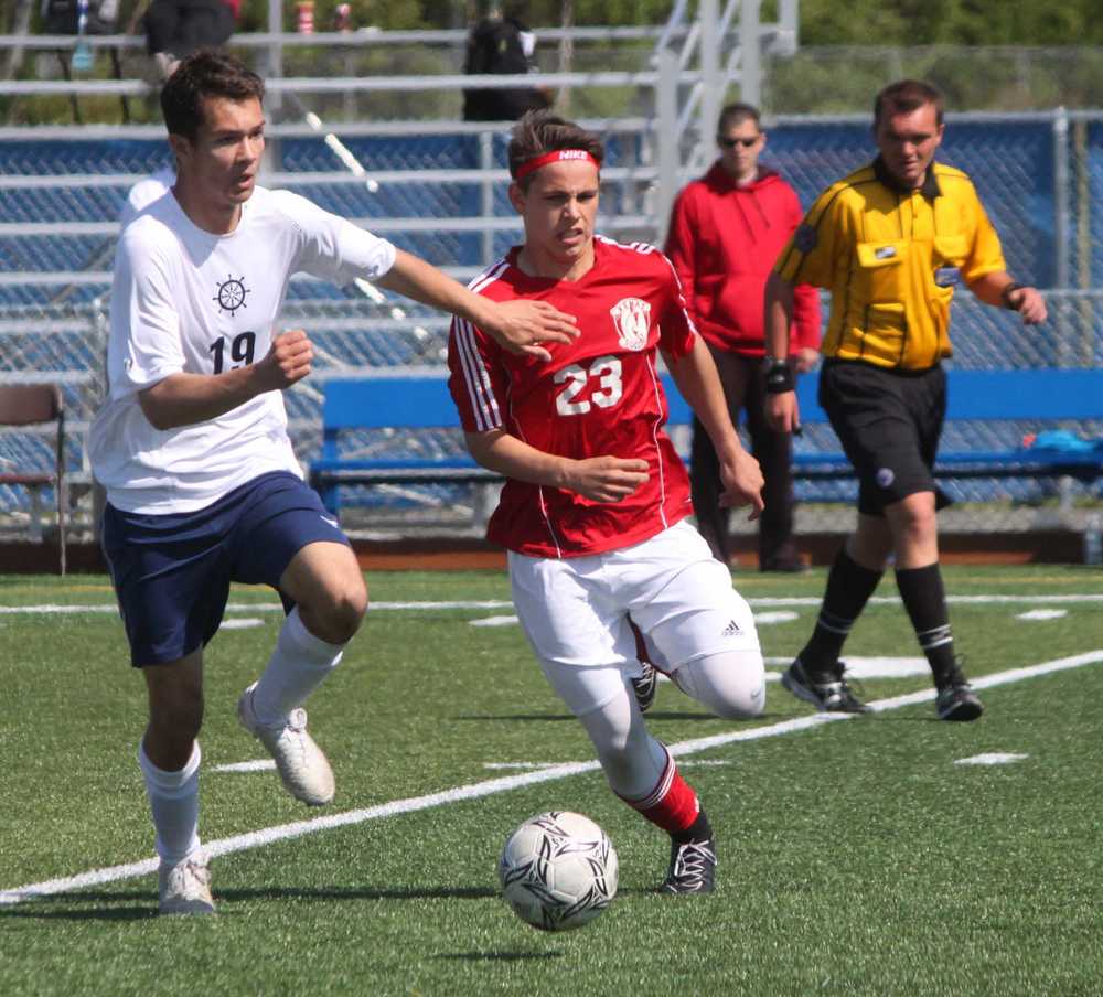 Homer senior Flynn Bloom (19) chases the ball with Kenai Central freshman Zack Tuttle (23) in the second half of Thursday's boys state quarterfinal match at Bartlett High School in Anchorage. The Kardinals won 1-0, their first ever state match victory.