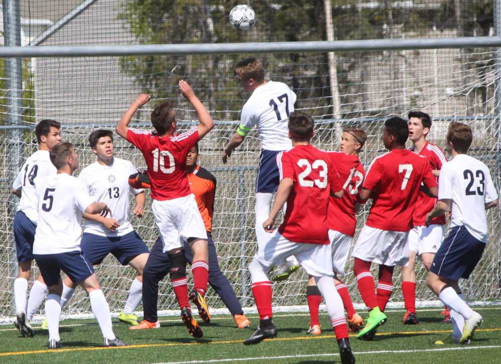 Homer senior Drew Brown (17) gets his head on a Homer corner kick above Kenai freshman Braydon Goodman (10) in the second half of Thursday's boys state quarterfinal match at Bartlett High School in Anchorage, while Homer senior Filip Reutov (5), senior Ben Knisely (13) and senior goalkeeper Eric Hill (partially hidden) look on. The Kardinals won 1-0, their first ever state match victory.