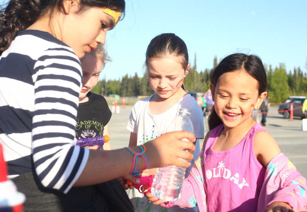 Photo by Kelly Sullivan/ Peninsula Clarion Maddy Triana, Sienna Luataret and Emma Glassmarker load tiny squirt guns during the 2015 Relay For Life Friday, May 29, 2015, at the Soldotna Regional Sports Complex in Soldotna, Alaska.