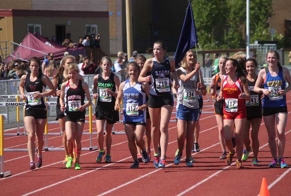 Kenai Central senior Allie Ostrander (488) jogs in front of the crowd with the field of runners after winning the 4A girls 3,200-meter race at the Alaska state track and field meet at Dimond Alumni Field in Anchorage.