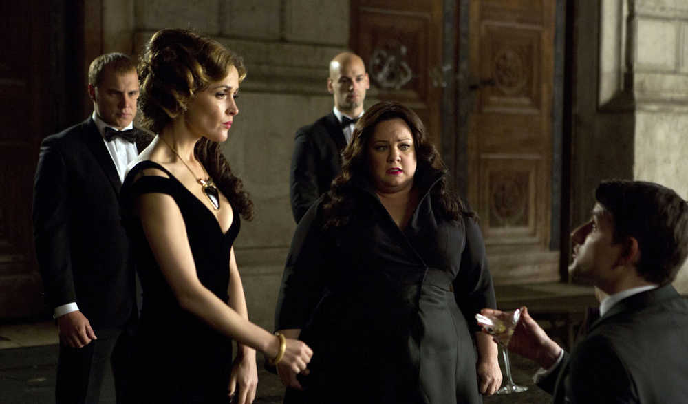This photo provided by Twentieth Century Fox shows, Melissa McCarthy, second right, infiltrating an arms dealing ring led by Rose Byrne, left, in a scene from the film, "Spy." (Larry Horricks/Twentieth Century Fox via AP)