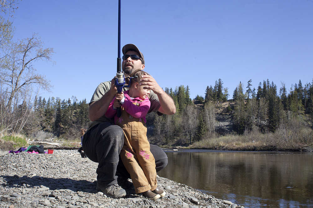 Photo by Rashah McChesney/Peninsula Clarion  In this May 17, 2014 file photo,  Charlie Black chats with a friend as his daughter Zoe Black, 4, tries to get back to fishing the Anchor River. While king salmon runs have struggled in the Cook Inlet in recent years, the Anchor River is seeing a banner year of returns and Alaska Department of Fish and Game managers announced an additional three days of fishing for the season.