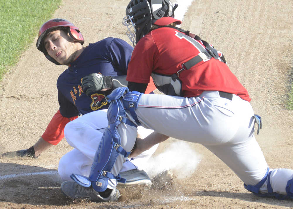 Photo by Kelly Sullivan/ Peninsula Clarion Peninsula Oiler's umpire Lukas Hermanson gets Fairbanks Goldpanner's Renae Martinez out at home base Thursday, June 11, 2015, at Coral Seymour Ballpark in Kenai, Alaska.