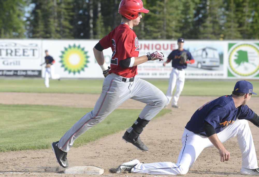 Photo by Kelly Sullivan/ Peninsula Clarion Peninsula Oiler's Ted Boeke makes it safely to first plate while Fairbanks Goldpanner's first baseman unsuccessfully tries to get him out Thursday, June 11, 2015, at Coral Seymour Ballpark in Kenai, Alaska.
