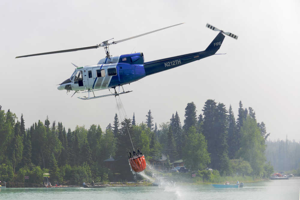 Ben Boettger/Peninsula Clarion A helicopter returns from a dumping run on the north shore of the Kenai River on Tuesday, June 16.