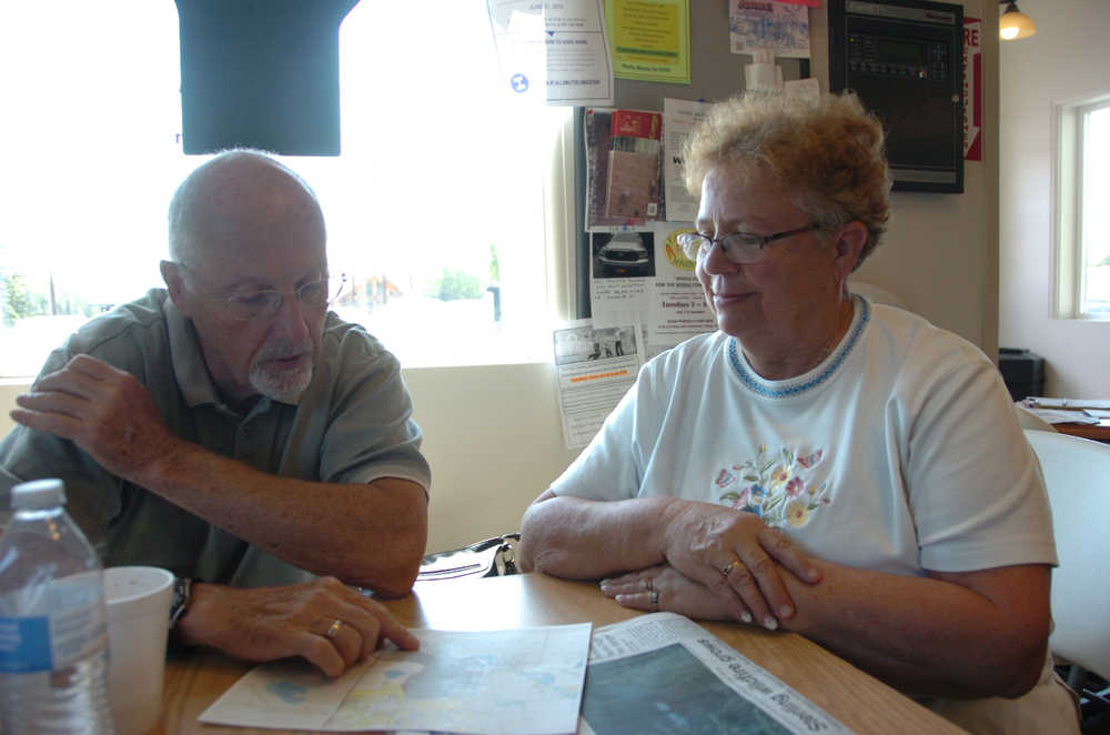 Clyde McLeod (left) and his wife, Donna (right), examine where the Card Street Fire is in relation to their home on Humpy Road while at the Sterling Community Center on Tuesday. Photo by Megan Pacer/Peninsula Clarion