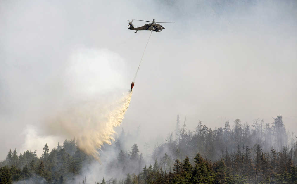 An Alaska Army National Guard UH-60 Black Hawk helicopter from 1st Battalion, 207th Aviation Regiment, drops approximately 700 gallons of water from a "Bambi Bucket" on to the Stetson Creek Fire near Cooper Landing Wednesday. Two National Guard Black Hawk helicopters flew a total of 200 bucket missions, dumping more than 144,000 gallons of water on the 300-acre Stetson Creek fire. (U.S. Army National Guard photo by Sgt. Balinda O'Neal)
