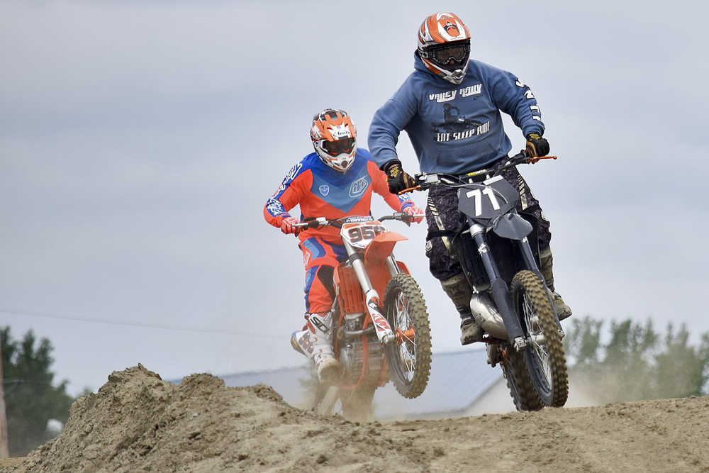 Photo by Rashah McChesney/Peninsula Clarion  Racers land jumps during a state motocross meet on Saturday June 20, 2015 at the Twin City Raceway in Kenai, Alaska.