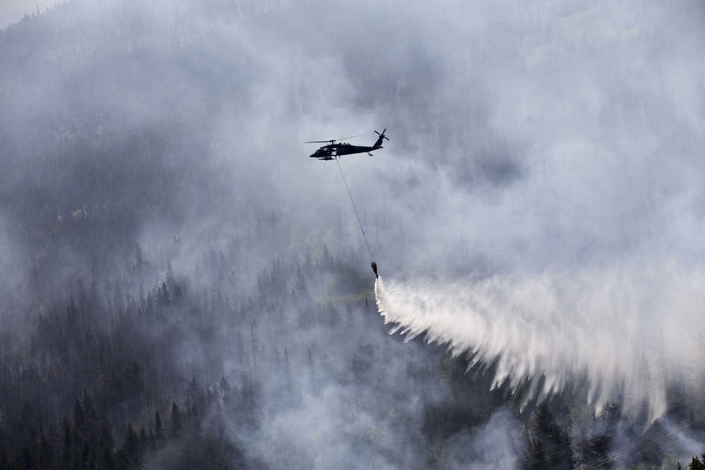 An Alaska Army National Guard UH-60 Black Hawk helicopter from 1st Battalion, 207th Aviation Regiment, drops approximately 700 gallons of water from a "Bambi Bucket" on to the Stetson Creek Fire near Cooper Landing, Alaska, June 17. Two AKARNG Black Hawk helicopters flew a total of 200 bucket missions, dumping more than 144,000 gallons of water on the 300-acre Stetson Creek Fire on the Kenai Peninsula. (U.S. Army National Guard photo by Sgt. Balinda O'Neal)