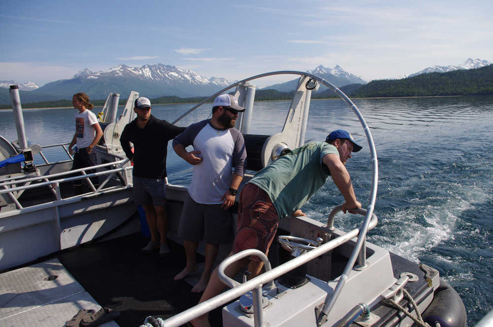 Crew from the Independence and the Solstice watch while skipper Louie Flora works on tying the F/V Eagle Claw up to the F/V Independence in Pile Bay  on June 16, 2015. The three Homer boats traveled the length of Iliamna Lake rafted together.