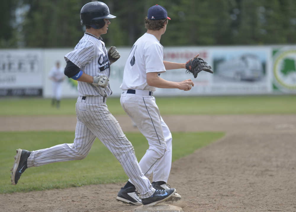 Photo by Kelly Sullivan/ Peninsula Clarion Post 33 Chugiak Mustang Jake Kindred slows down as he crosses first base because Kenai Post 20 Twins Joey Becher caught Saturday, June 27, 2015, at Coral Seymour Park in Kenai, Alaska.