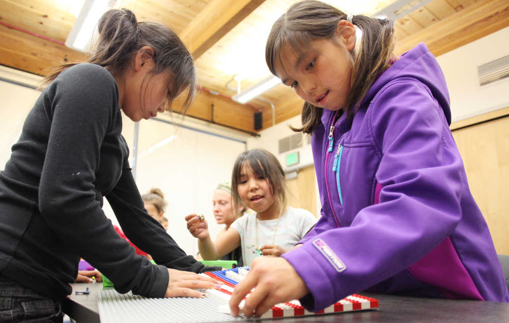 Photo by Kelly Sullivan/ Peninsula Clarion Natalie Ahkinga (right) and her sisters Jewel Koozaata (left) and Adrienne Okpealuk (middle) work together to make a U.S. Flag from Legos Monday, June 29, 2015, at the Kenai Community Library in Kenai, Alaska.