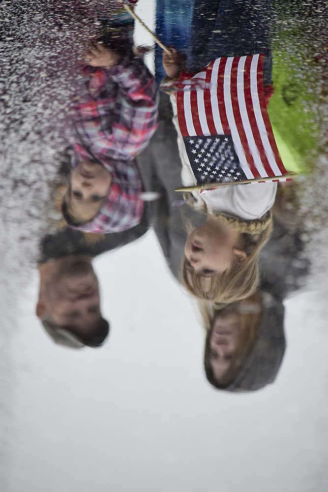 Photo by Rashah McChesney/Peninsula Clarion  Kenai City Manager Rick Koch smokes a cigar while driving a '73 Mustang with the Kaknu Kruzers car club during the annual Independence Day parade on Saturday July 4, 2015 in Kenai, Alaska.