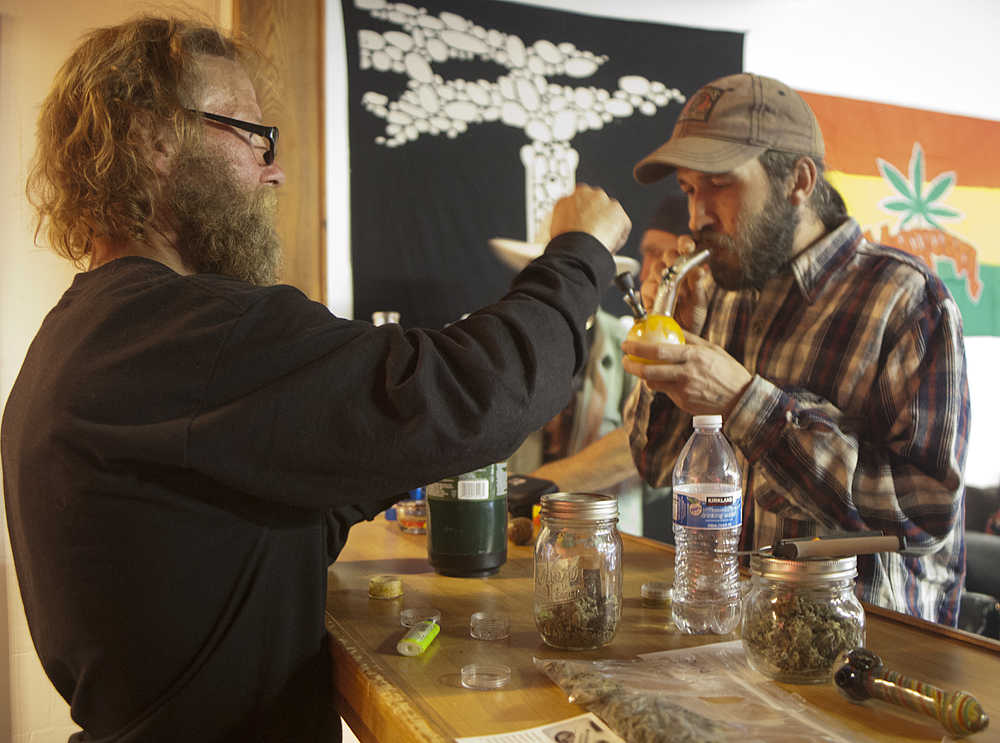 Tim Brookes, of Kenai, (right) examines a cannabis product while Kirk Daman, of Homer, (left) helps other members of the Green Rush Events Clubhouse on Saturday in Kenai. Photo by Megan Pacer/Peninsula Clarion