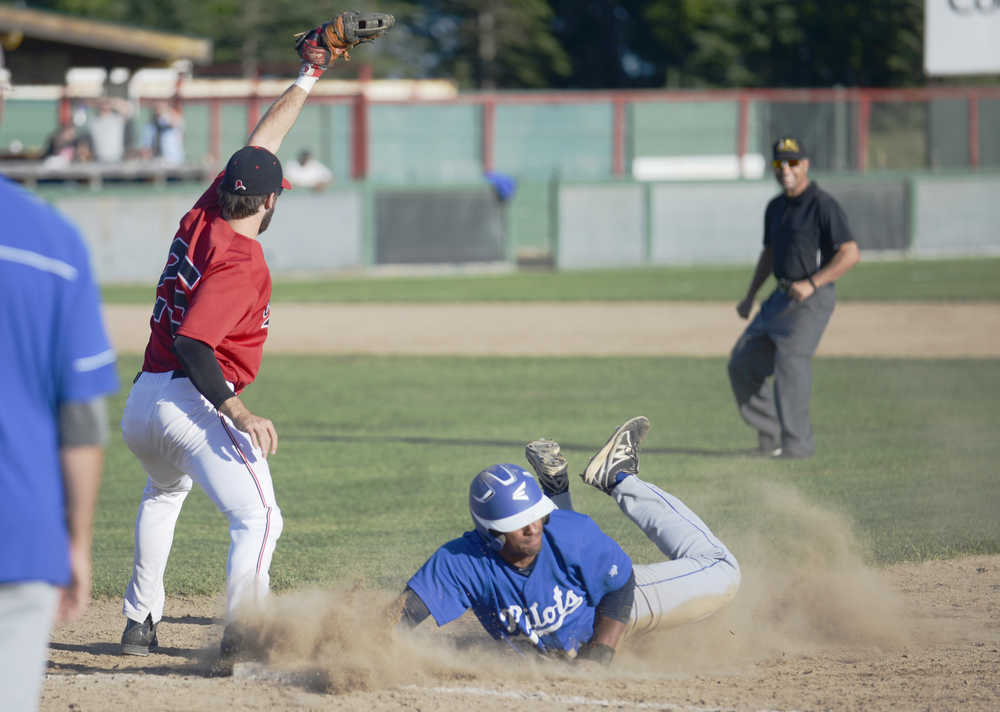 Ben Boettger/Peninsula Clarion First baseman  tags out  after 's unsucessful attempt to steal second base.