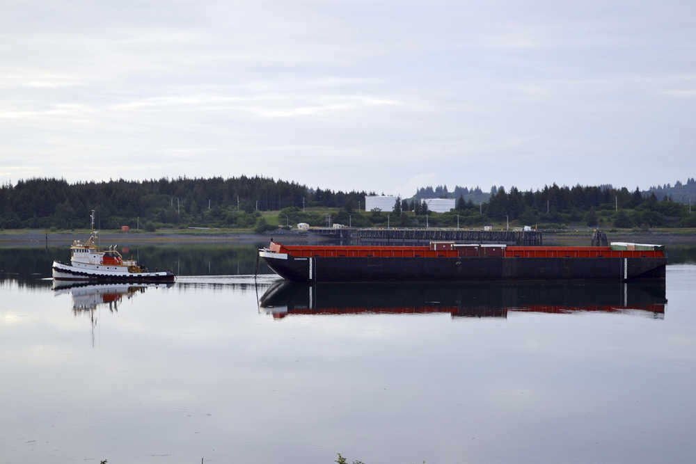 In this proto provided by Alaska Department of Environmental Conservation, a barge is docked off Womens Bay in Kodiak, Alaska, Wednesday, July 15, 2015. The barge that will be used to haul away tons of marine debris - some likely from the 2011 tsunami in Japan - from Alaska shores arrived at Kodiak on Wednesday. (Candice Bressler/Alaska Department of Environmental Conservation via AP)