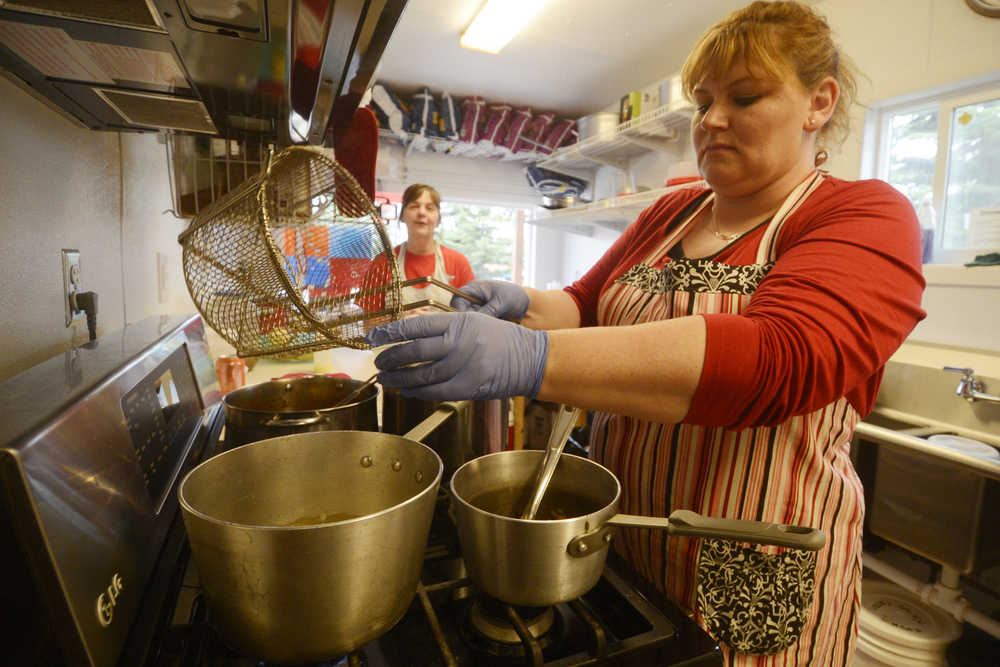 Photo by Kelly Sullivan/ Peninsula Clarion Rajun Cajun co-owner Billie Sylvester works on the daily special at the Thursday, July 16, 2015, in Soldotna, Alaska. The food truck, which opened for the season one week ago, is one of the many mobile-style estanlishments that are very popular in the city right now, said owner,  Nocona Doucet who is a transplant from Louisana. She said she opened the business three years ago because she had a hard time finding very seasoned food in the area. "You'll find cajun people try to feed everybody," Doucet said.