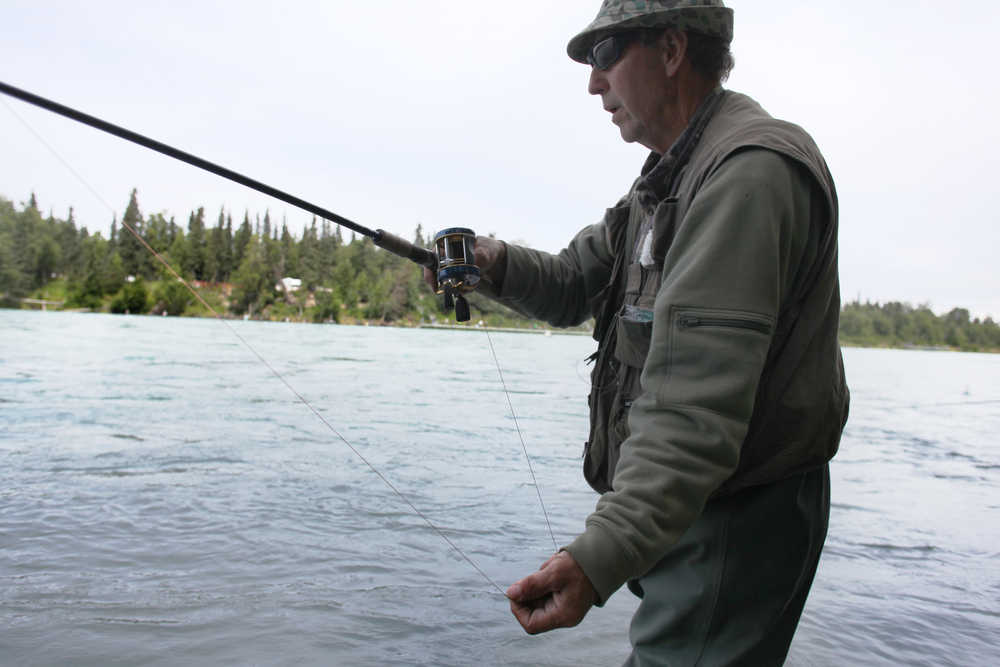 Ben Boettger/Peninsula Clarion Art Baker twitches his hook at the end of a drift by pulling out the line with his hand on the bank of the Kenai, behind the Kenai River Center in Soldotna, on Tuesday, July 21.